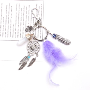 Close-up of dreamcatcher keychain with purple feathers and Hamsa hand charm