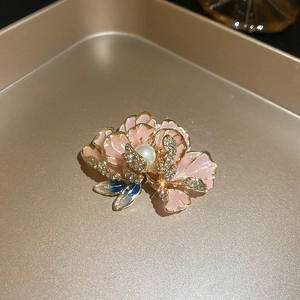 Macro shot of French pink enamel flower brooch with pearl and crystal details