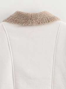 Detail shot of warm beige faux shearling jacket with camel contrast collar and plush texture