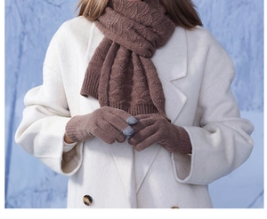Détail de gants en tricot marron avec bouts tactiles et motif de torsades classique