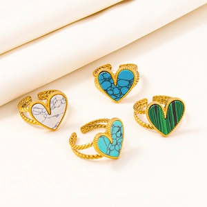 Detail of four adjustable gold-plated stainless steel rings with colorful heart-shaped stones