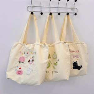Detailed view of canvas tote bags with cute cartoon embroidery and drawstring closures