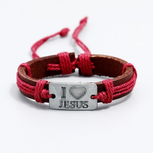 Adjustable brown leather and red braided rope bracelet with metallic charm on white backdrop