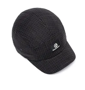 Detailed macro view of checkered camper hat fabric with brand patch and metal eyelets
