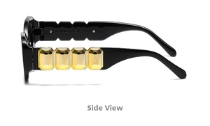 Detail of black sunglasses arm featuring four gold geometric metal blocks on the temple