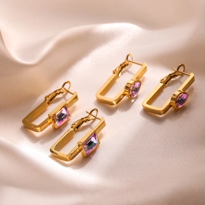 Gold plated geometric square earrings with purple zircon on pink silk background