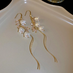 Détail des boucles d'oreilles muguet avec chaînes dorées et perles de cristal