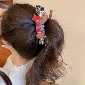 Detail of cute brown plush dachshund hair clip with red and blue plaid bow on hair