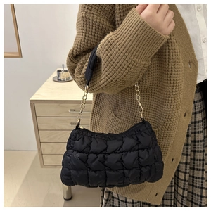 Detail of black quilted cloud bag showing soft padded texture and golden chain strap