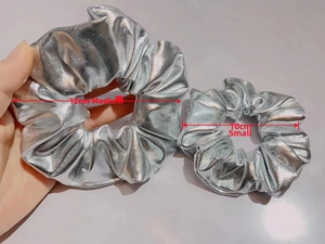 Detail view of silver metallic scrunchies in 10cm and 12cm sizes with glossy leather texture