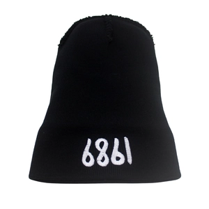 Black knit beanie with white embroidered 1989 text on a clean white background