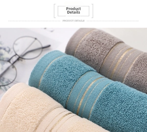 Detail view of thick absorbent cotton towels with golden stripes in assorted colors