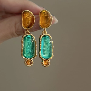 Elegant gold earrings with amber and teal resin irregular pendants in a vintage art style