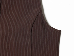Gros plan du tissu marron à rayures montrant les détails des coutures de la veste sans manches