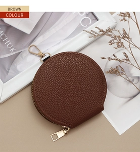 Macro detail of brown lychee pattern leather mini round coin purse with gold zipper