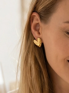 Detail view of 18k gold plated stainless steel heart earrings with hammered texture finish