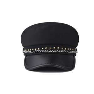 Close-up of black fiddler hat featuring golden star rivets and a silver metal chain detail