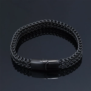 Detailed close-up of a masculine black stainless steel braided chain bracelet with a matte clasp