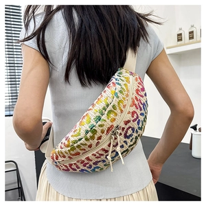 Detail of straw waist bag featuring colorful leopard pattern and tassel zipper on a model