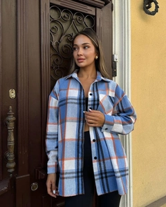 Detail of blue and orange plaid flannel shirt featuring dual chest pockets and buttons