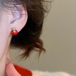 Close-up of red fortune bag earrings with gold plating and zircon inlay on model