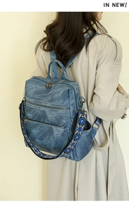 Detail of retro denim backpack with ethnic bohemian embroidered wide shoulder strap