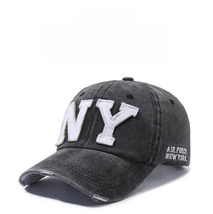 Detailed view of NY embroidery and distressed brim on gray washed cotton baseball cap