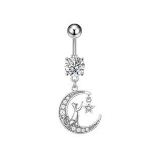 Macro shot of silver belly ring with zircon stones featuring crescent moon and cat design