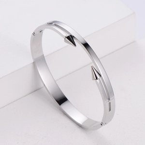 Detailed shot of polished silver bangle with double spear arrows and minimalist hinge