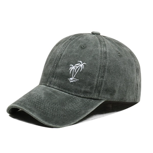 Detailed close-up of white coconut tree embroidery on a dark grey washed cotton baseball cap