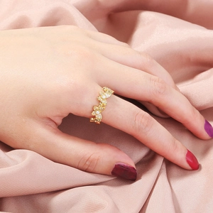 Detailed close-up of a gold butterfly ring with inlaid zircons worn on a finger