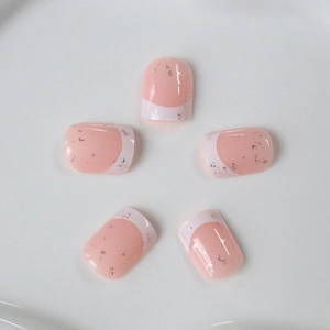 Short square French press-on nails with pink base, white tips, and silver glitter flakes