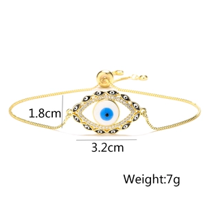 Detail view of gold evil eye bracelet with white enamel and sparkling zircon accents