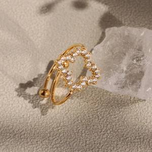 Bague trèfle dorée sertie de zircons blancs et cristal brut sur fond gris