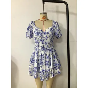 Detail of blue and white floral dress with V-neckline and layered ruffle hem design