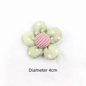 Detail of 4cm green polka dot fabric flower with pink striped center for DIY crafts