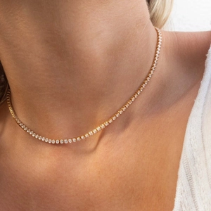 Close-up of elegant gold tennis necklace with sparkling cubic zirconia on model neck