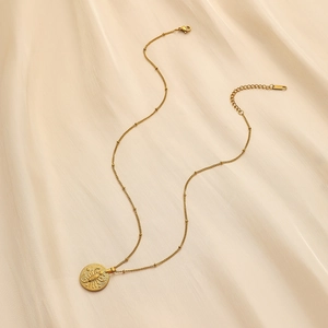Detailed macro view of gold stainless steel Scorpio zodiac coin pendant on silk