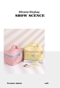 Quilted floral cotton cosmetic bag with top handle and embroidery detail shown in home setting