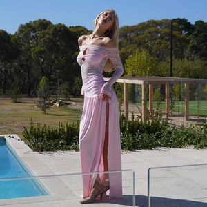Detailed close-up of pink lace sleeves and high side slit on an off-shoulder dress