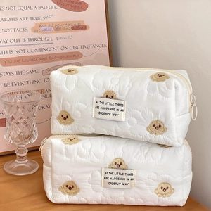 Quilted white cotton makeup bag with yellow octopus embroidery and zipper closure