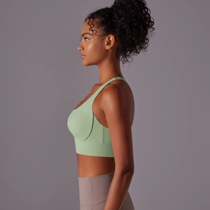 Vista laterale del reggiseno da yoga verde pallido in tessuto elasticizzato senza cuciture