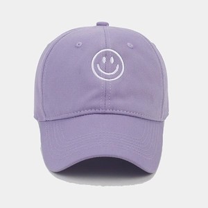 Detail of white smiley face embroidery on a soft purple cotton baseball cap