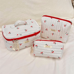 Three-piece quilted cherry print cosmetic bag set with red zippers and floral patterns
