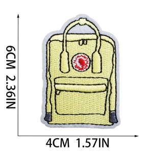 Detail view of yellow backpack embroidery patch showing 6cm by 4cm size dimensions