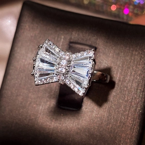 Macro detail of silver bow ring featuring sparkling trapezoid and round cut zircons