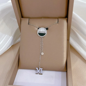 Silver titanium necklace with Roman numeral round pendant and crystal tassel in a box