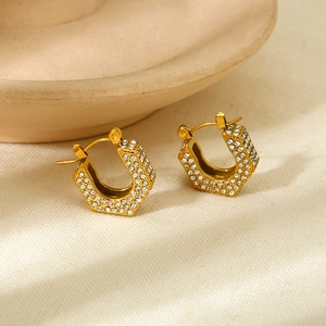 Macro detail of 18k gold plated hexagonal hoop earrings with sparkling white zircons