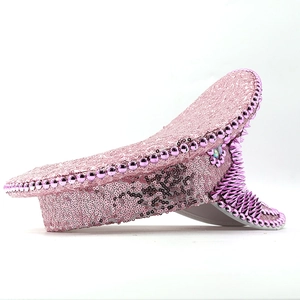 Detailed side view of pink sequin military hat with purple rhinestones and silver studs