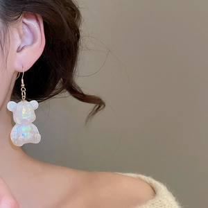 Close-up of model wearing iridescent resin bear earrings with a stylish minimalist design